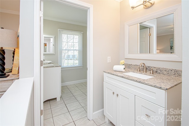 bathroom with vanity, crown molding, baseboards, and tile patterned floors