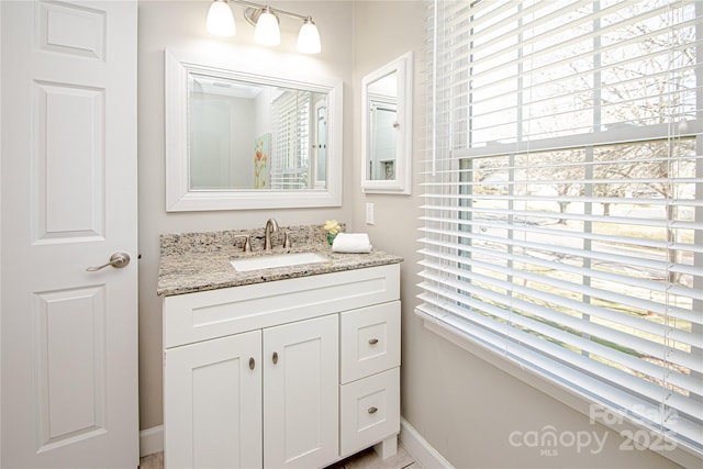 bathroom with vanity, plenty of natural light, and baseboards