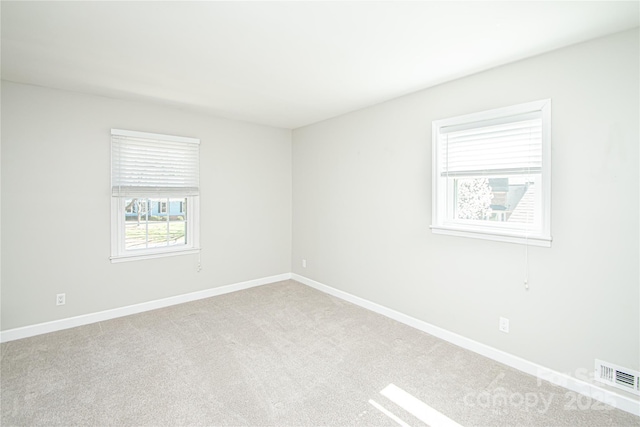 spare room featuring visible vents, baseboards, and carpet flooring