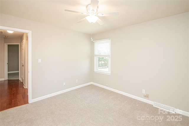 carpeted empty room with visible vents, baseboards, and a ceiling fan