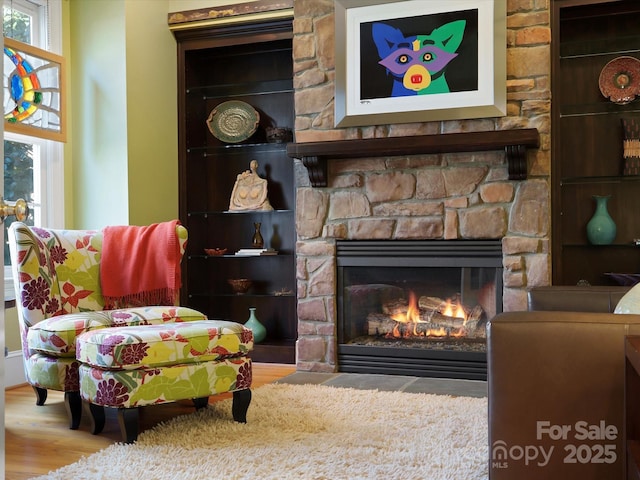 living area with a healthy amount of sunlight, wood finished floors, and a fireplace