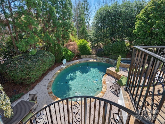 outdoor pool with an in ground hot tub and a patio