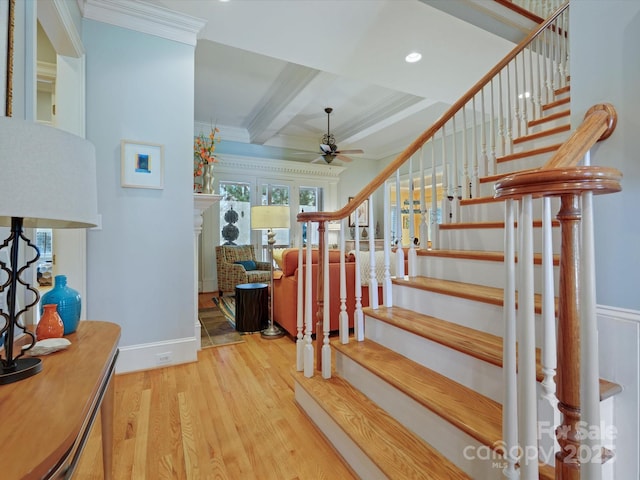 stairway featuring baseboards, ornamental molding, beam ceiling, wood finished floors, and a ceiling fan