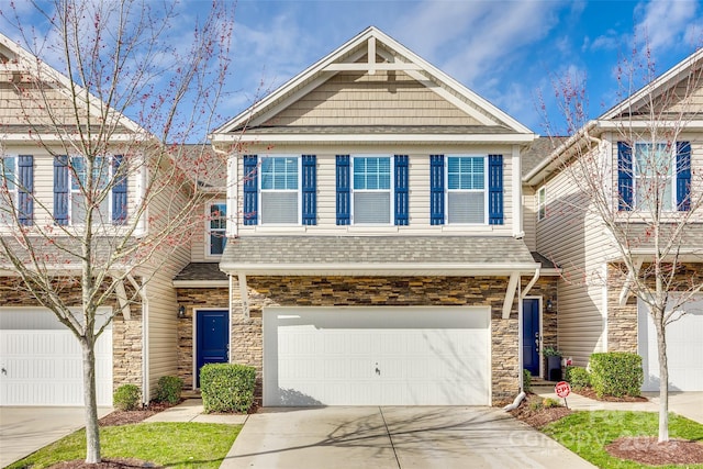 view of front of home with a garage, stone siding, roof with shingles, and driveway