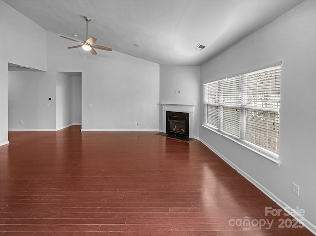 unfurnished living room with visible vents, ceiling fan, baseboards, a fireplace with flush hearth, and wood finished floors