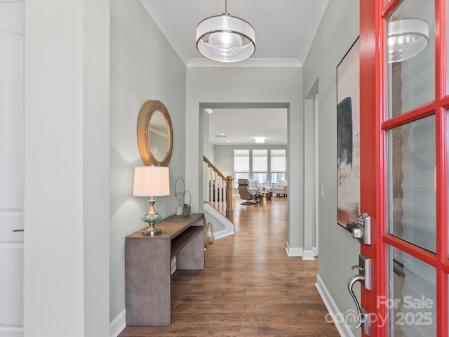 entrance foyer with ornamental molding, stairs, baseboards, and wood finished floors