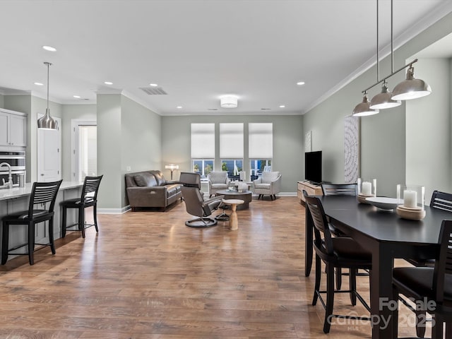 dining area featuring crown molding, baseboards, and wood finished floors