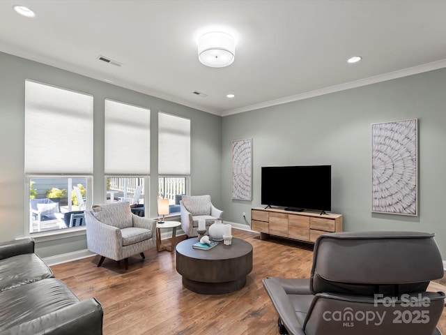 living room with ornamental molding, baseboards, and wood finished floors