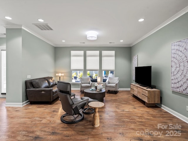 living area with visible vents, baseboards, and wood finished floors