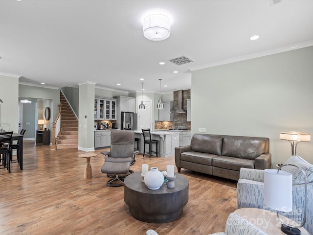 living room with stairs, recessed lighting, light wood-style floors, and visible vents