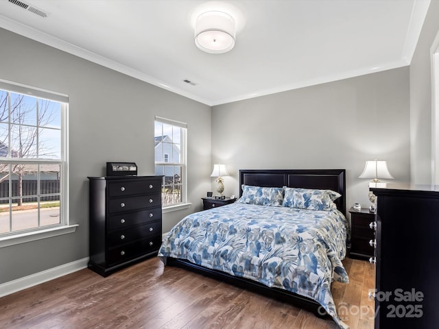 bedroom with visible vents, multiple windows, and wood finished floors