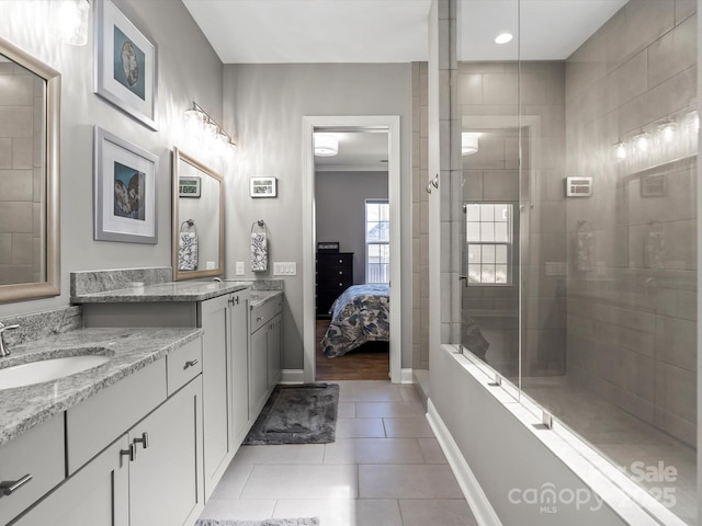 full bath featuring a sink, a tile shower, connected bathroom, tile patterned flooring, and baseboards