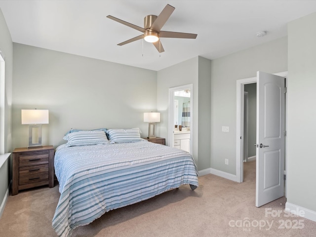 bedroom featuring light colored carpet, connected bathroom, baseboards, and ceiling fan