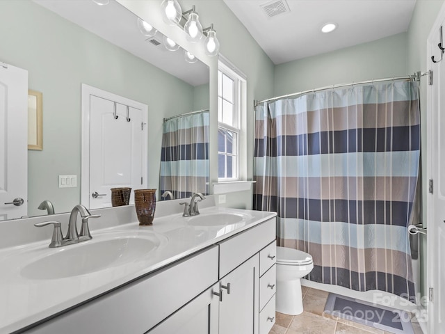 full bathroom with double vanity, toilet, visible vents, and a sink