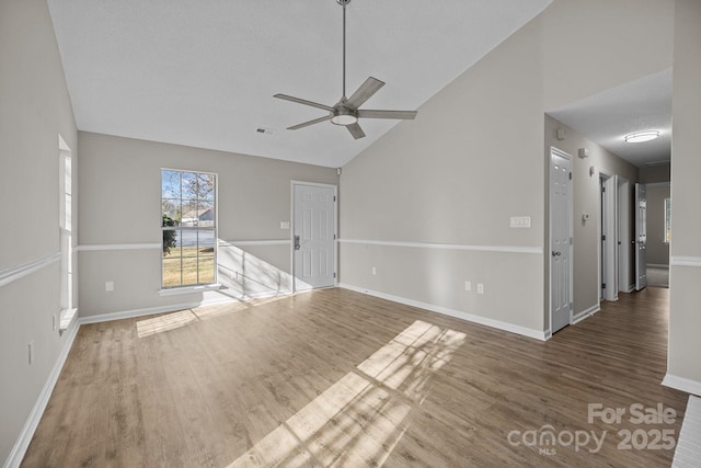 unfurnished living room featuring visible vents, a ceiling fan, baseboards, and wood finished floors