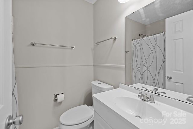 bathroom featuring a shower with shower curtain, toilet, and vanity