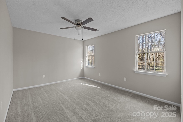 empty room featuring baseboards, carpet, ceiling fan, and a textured ceiling