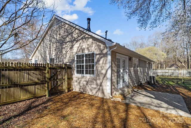 view of side of home featuring central AC and a fenced backyard