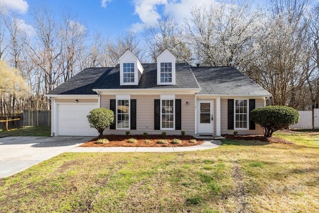 new england style home with an attached garage, concrete driveway, a front yard, and fence