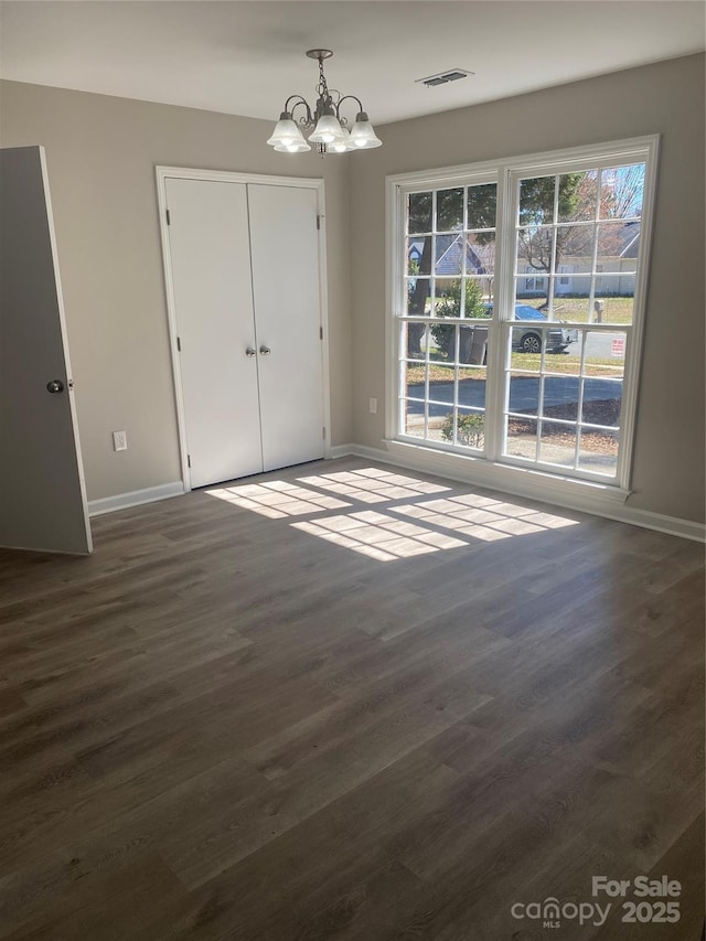 interior space with visible vents, baseboards, an inviting chandelier, and dark wood-style floors