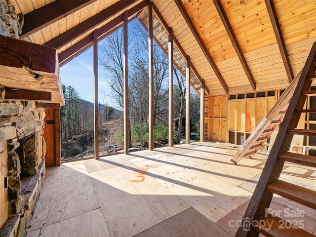 interior space featuring stairway, high vaulted ceiling, beam ceiling, an outdoor stone fireplace, and wood ceiling