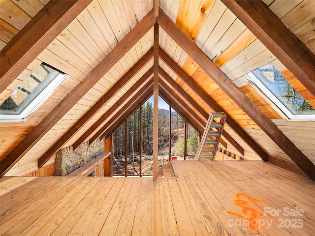 attic with a skylight and an upstairs landing