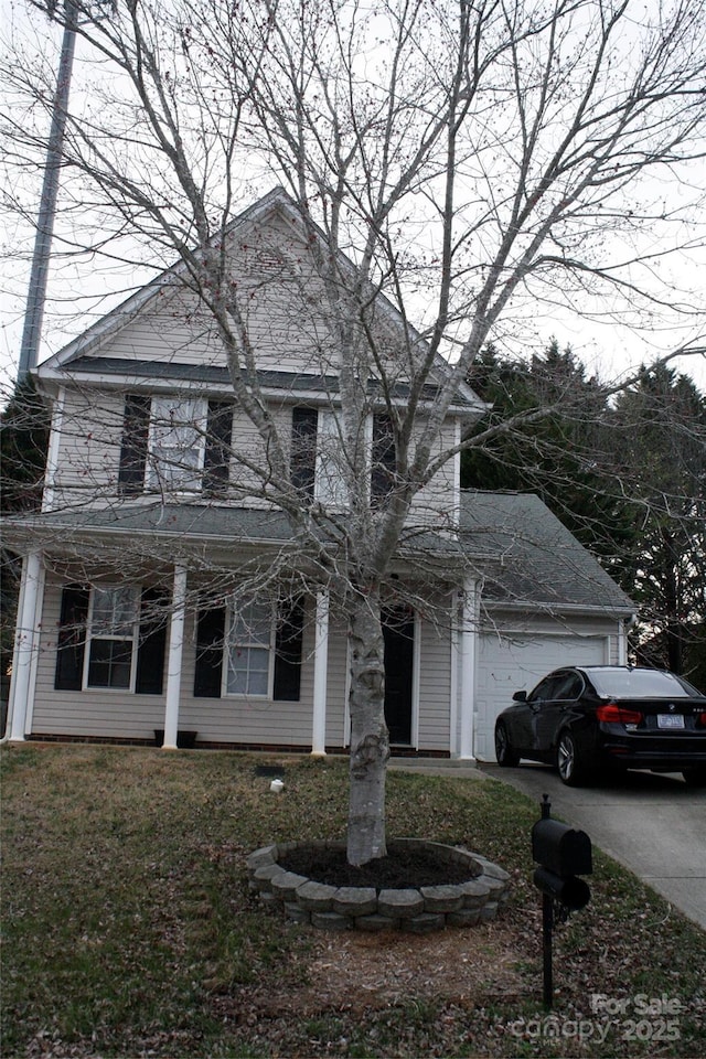 view of front of house with a front yard, an attached garage, and driveway