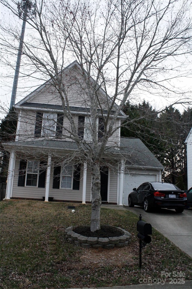 view of front facade with an attached garage, concrete driveway, and a front yard