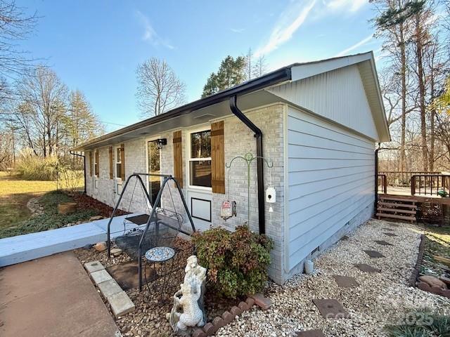 exterior space with brick siding and a deck