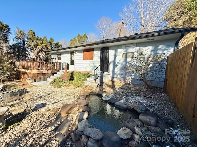 rear view of house with a deck and fence