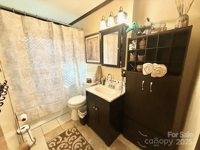 full bathroom featuring a shower with curtain, toilet, vanity, and tile patterned flooring