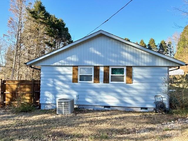 view of home's exterior with crawl space, central air condition unit, and fence