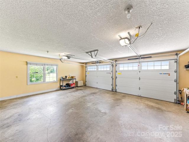 garage featuring a garage door opener and baseboards