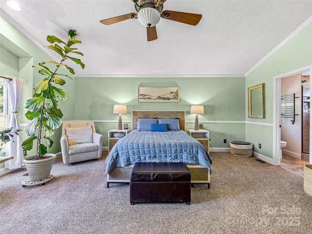 carpeted bedroom featuring ensuite bathroom, a textured ceiling, crown molding, and ceiling fan