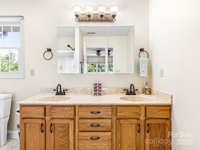 bathroom with a wealth of natural light, visible vents, and a sink