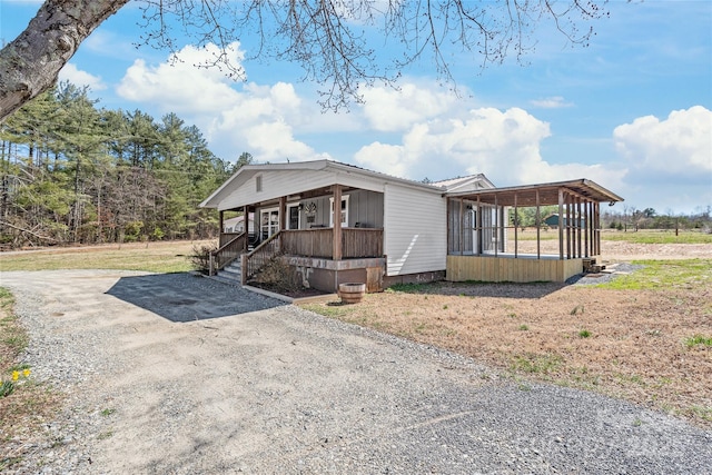 view of front of home featuring a porch, driveway, and a sunroom