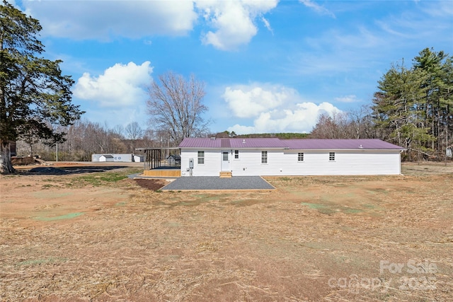 rear view of property featuring metal roof and a patio