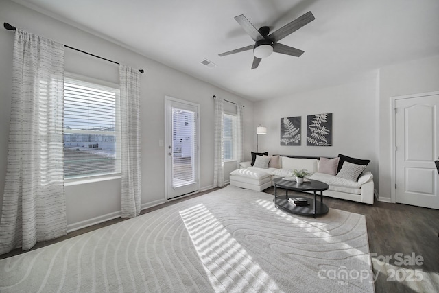 living area with a ceiling fan, visible vents, wood finished floors, and baseboards