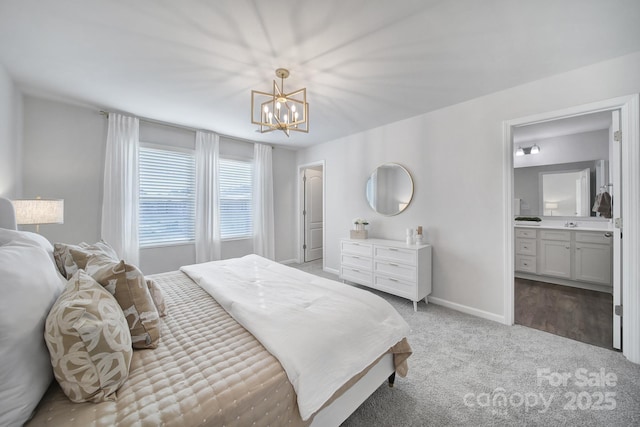 bedroom with a notable chandelier, carpet, baseboards, and connected bathroom