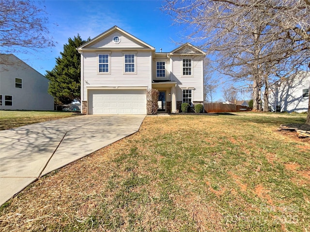 traditional-style house with a garage, a front lawn, and driveway