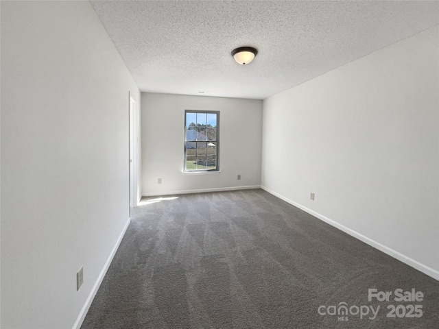 carpeted empty room featuring baseboards and a textured ceiling