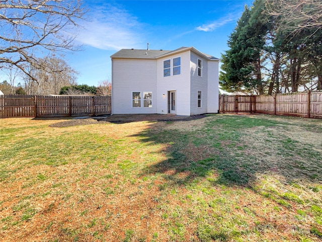 back of property with a yard and a fenced backyard