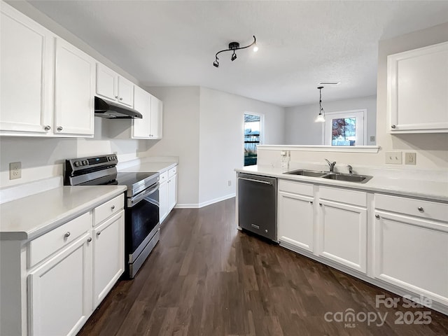 kitchen featuring under cabinet range hood, a sink, stainless steel appliances, light countertops, and dark wood-style flooring