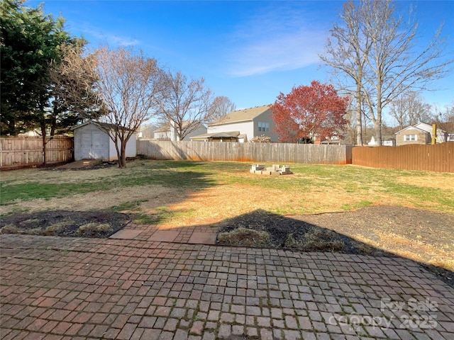 view of yard with an outbuilding, a fenced backyard, and a storage shed