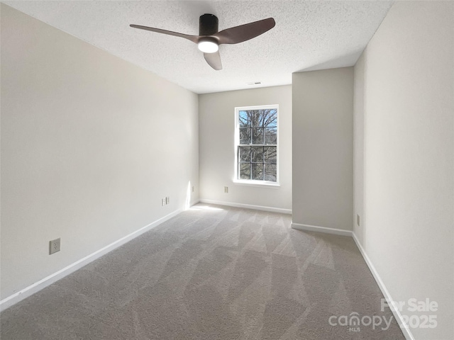 spare room with visible vents, baseboards, carpet, and a textured ceiling