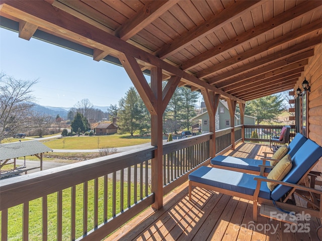 wooden deck featuring a yard and a mountain view