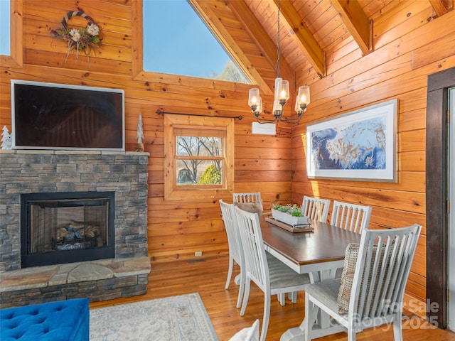 dining room featuring a chandelier, wooden ceiling, wood walls, wood finished floors, and vaulted ceiling with beams