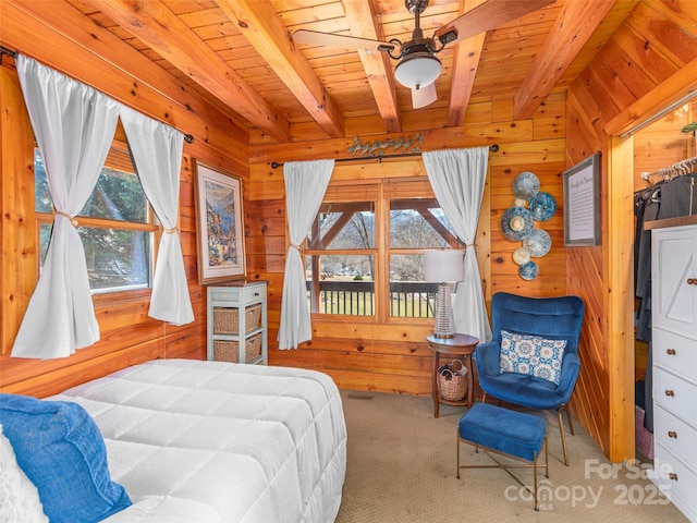 bedroom with beamed ceiling, wooden ceiling, carpet floors, and wood walls