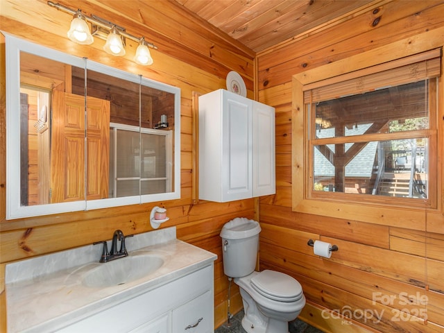 bathroom with toilet, wood ceiling, wooden walls, and vanity