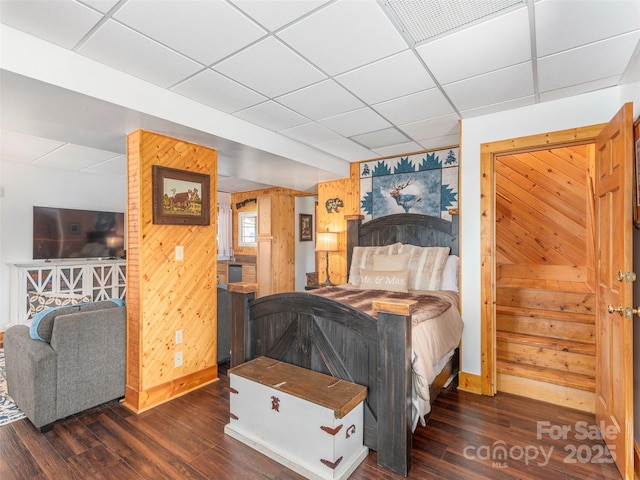 bedroom featuring a paneled ceiling, wood finished floors, baseboards, and visible vents